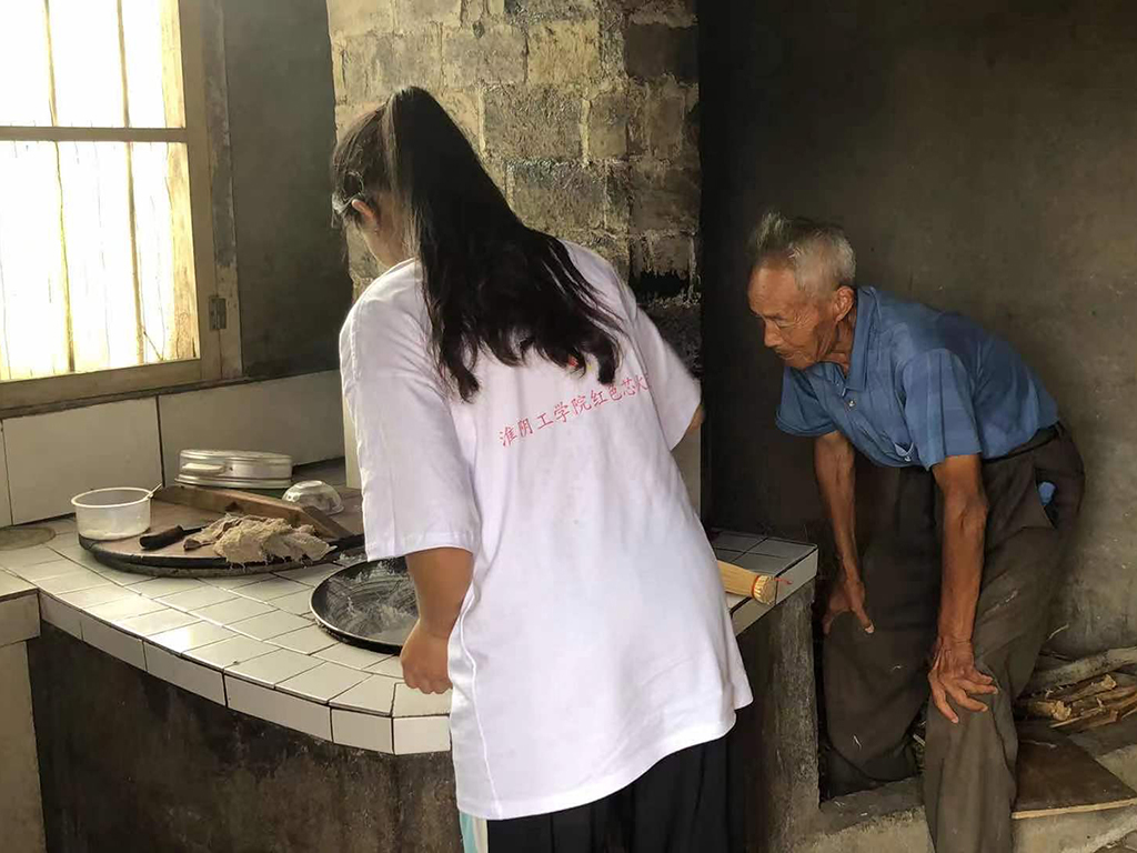 员工党员与抗美援朝英雄爷爷一起制作红色饮食“炒面”
